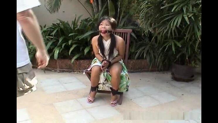 Attractive Asian babe restrained on a chair